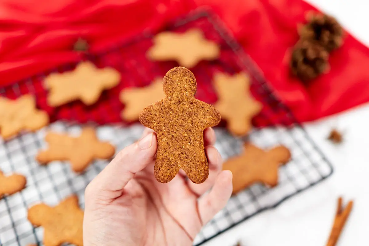 Thin gingerbread man cookie in hand.