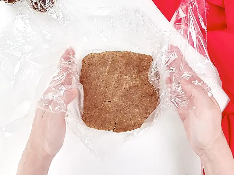 Wrapping dough in plastic wrap.