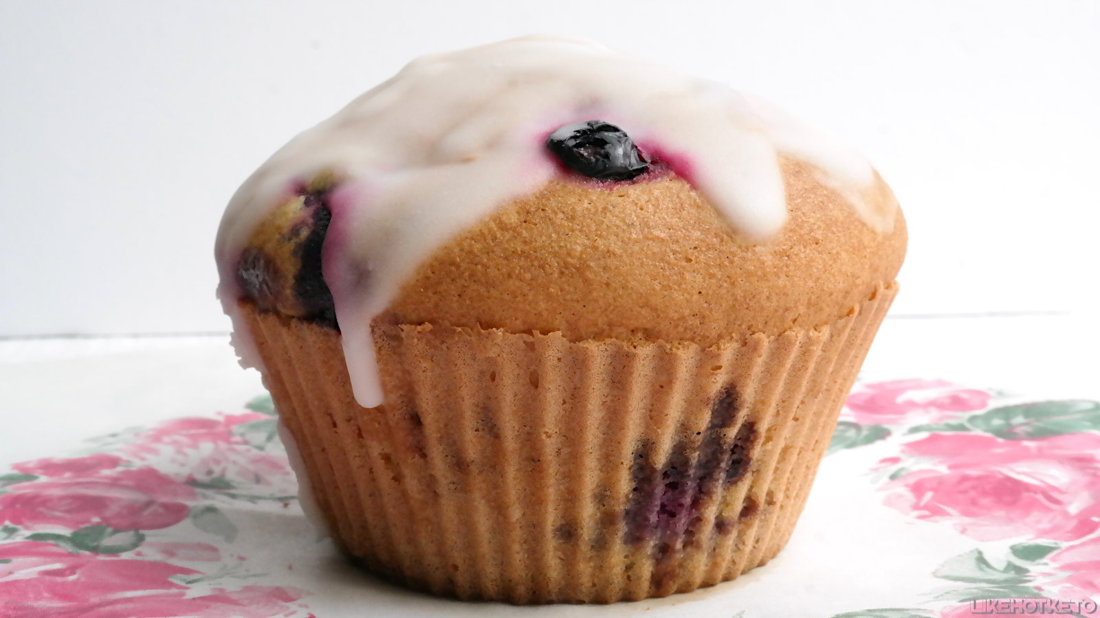 A large blueberry muffin covered in sugar-free lemon glaze.