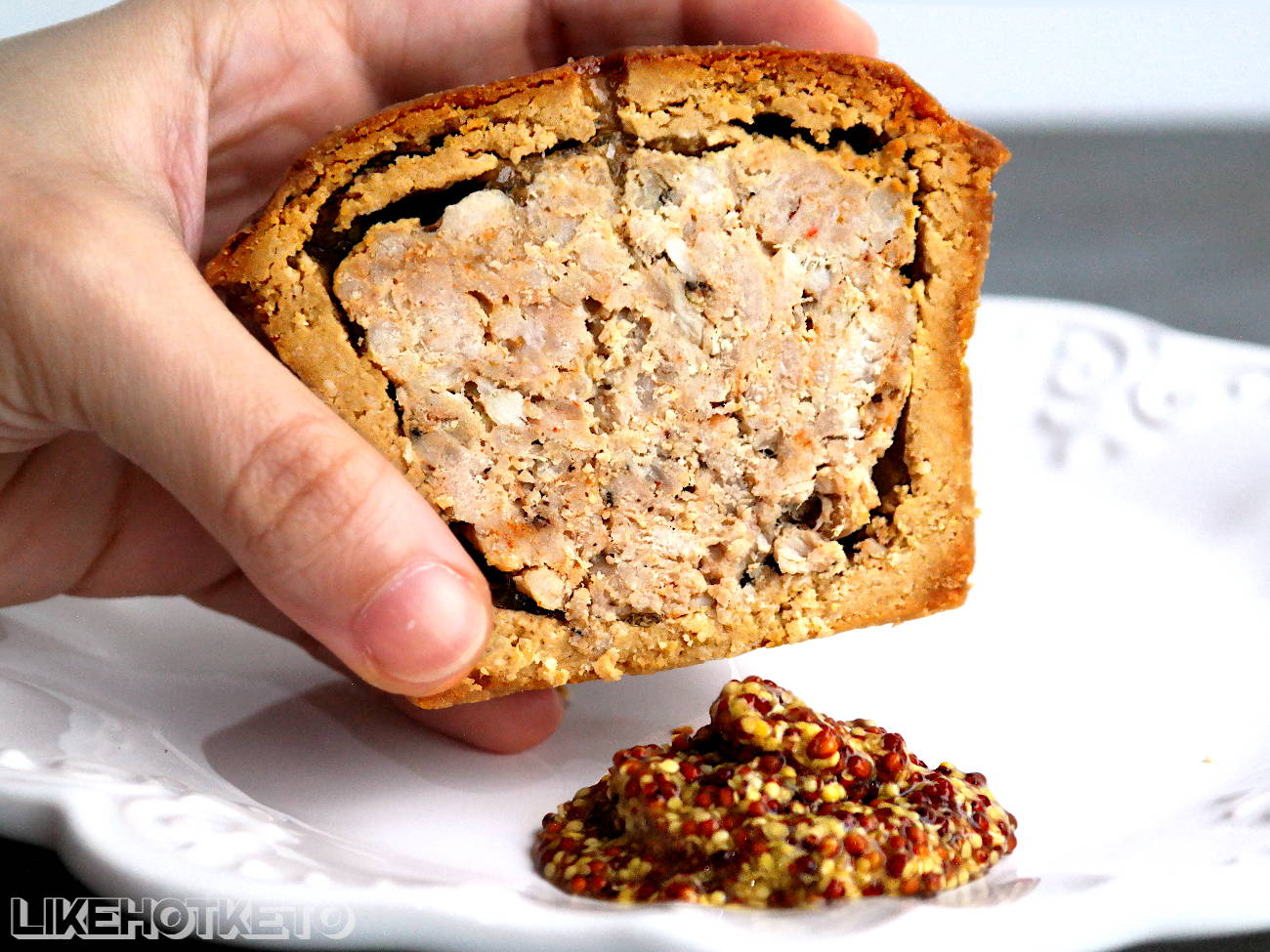 Gluten-free pork pie cut in half, showing the pork and jellied stock filling.