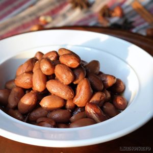 A bowl of broiled peanuts, with star anise and cinnamon.