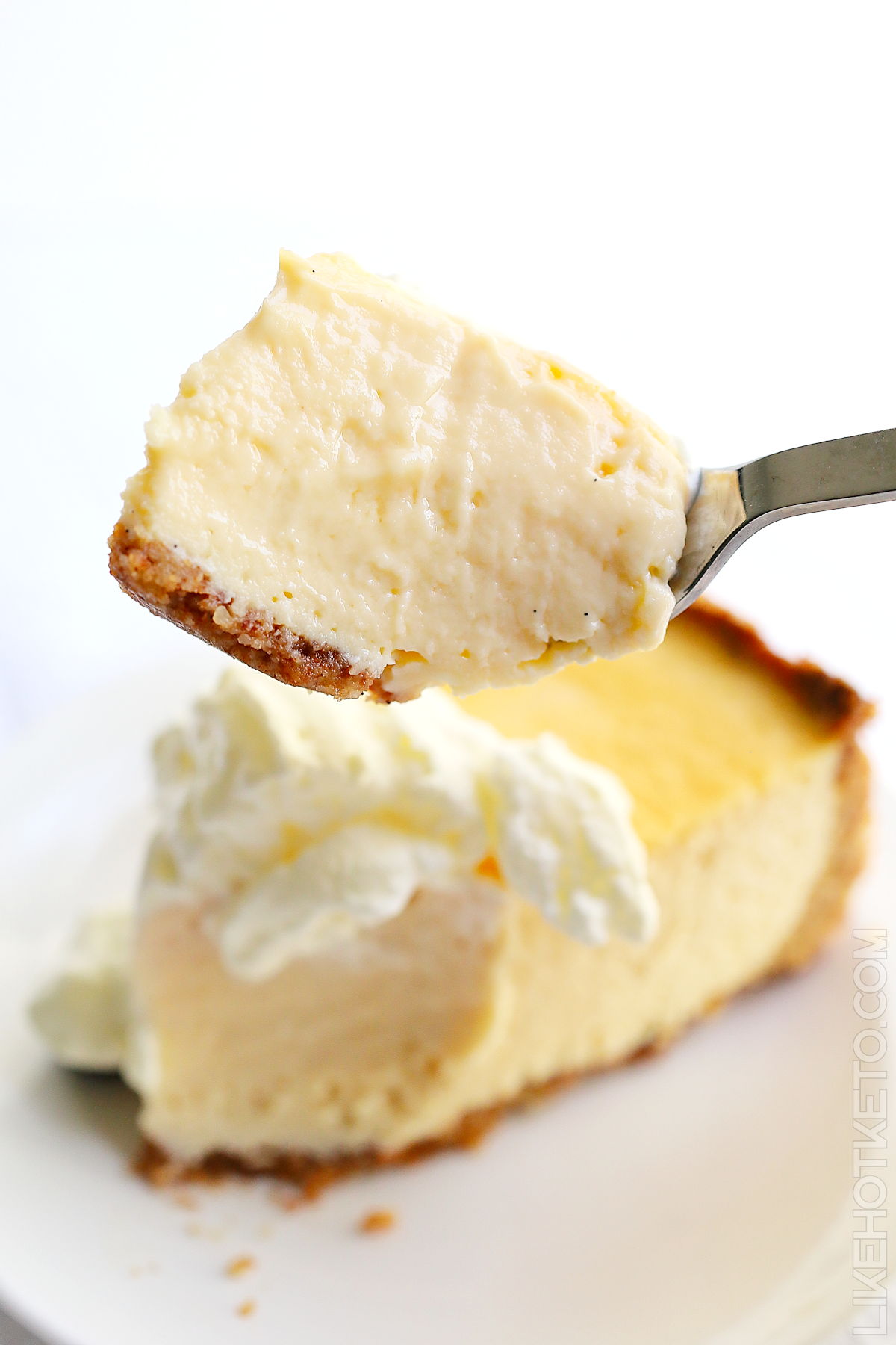 A bite of creamy keto vanilla cheesecake, on a fork.