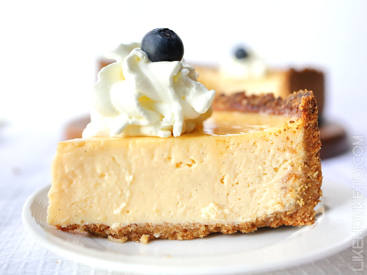 A large slice of keto vanilla cheesecake with honey Graham cracker crust.