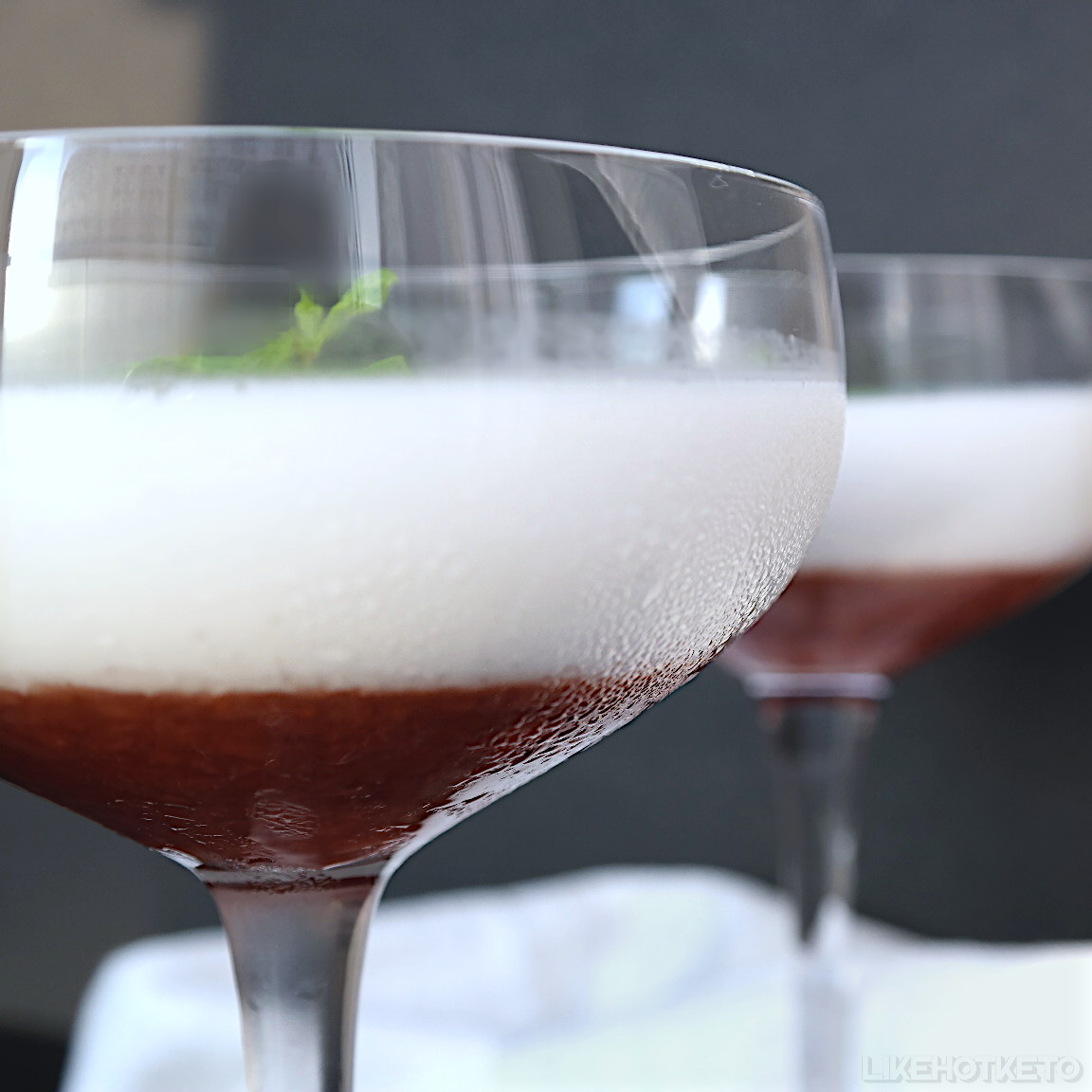Keto coconut milk panna cotta with strawberry sauce in cocktailglasses.