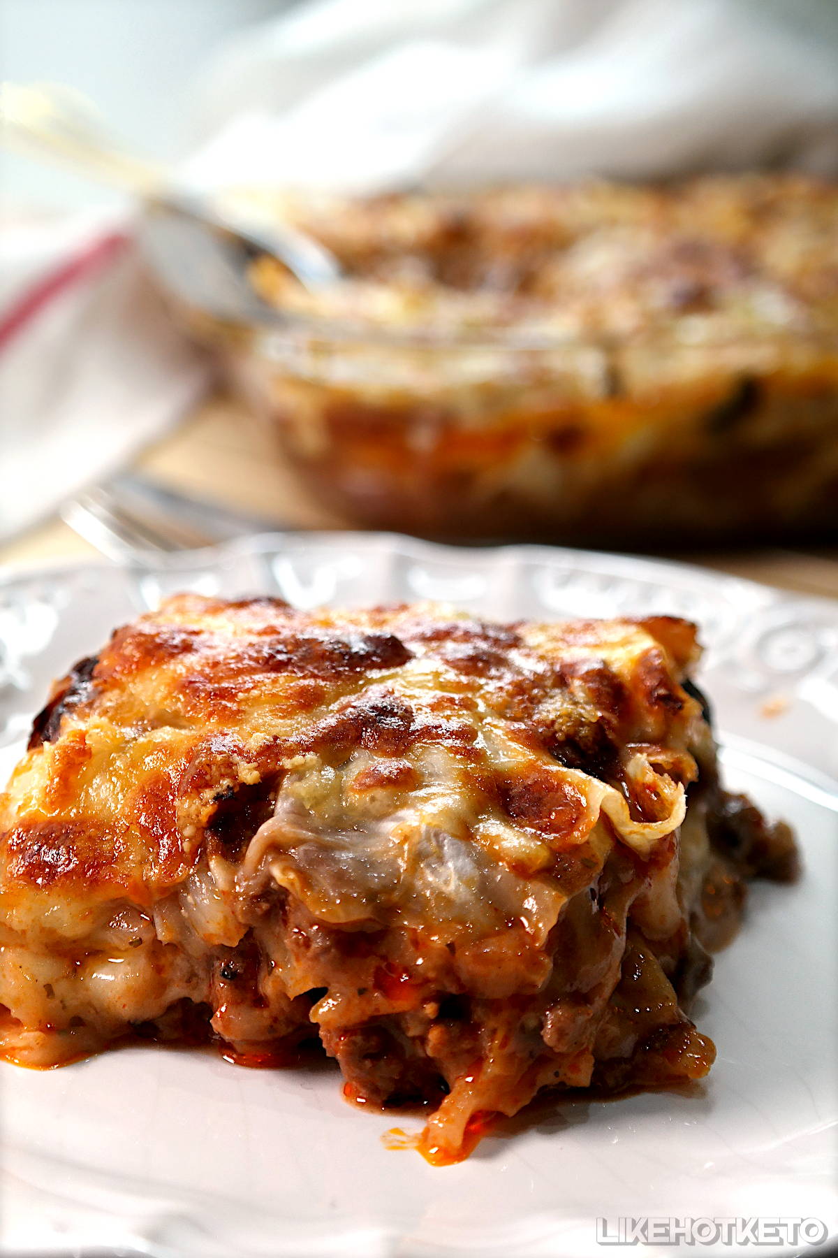 A slice of keto cabbage and meat lasagna, showing all the layers and crisp gratinated cheese topping.