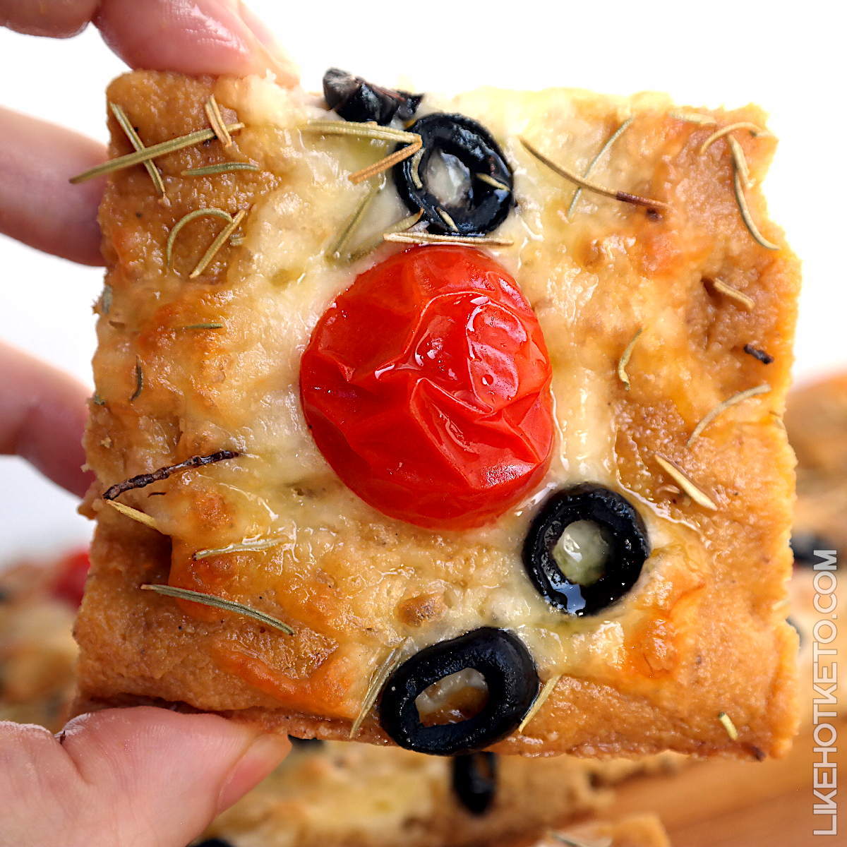 A slice of low-carb Italian focaccia with baked heirloom tomato.
