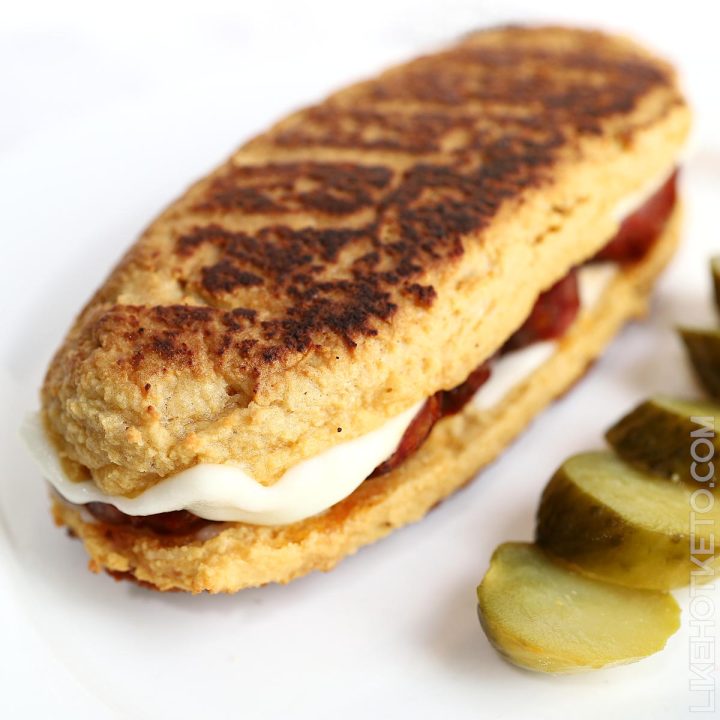 A sandwich made with keto bread bun cooked in a pan, with golden brown crust.