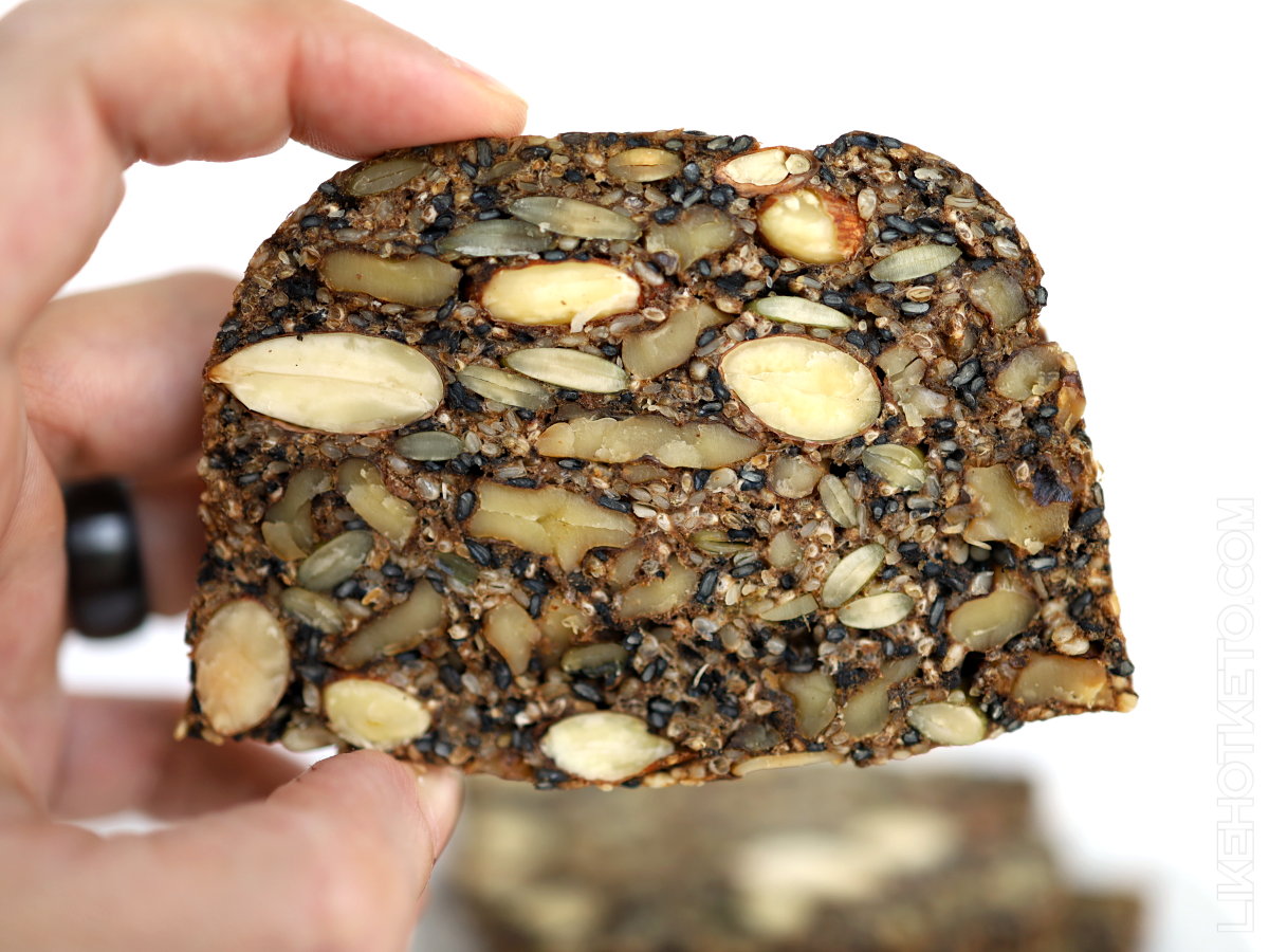 Slice of keto Danish bread with many nuts and seeds.
