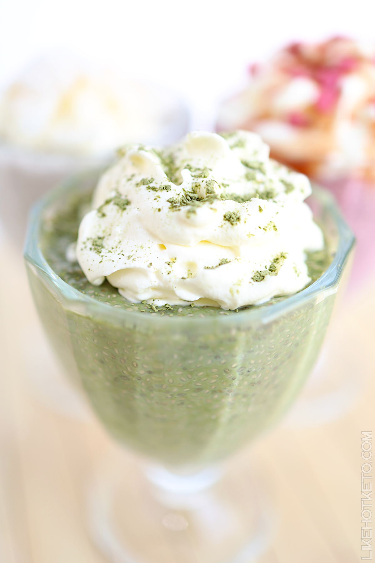 Green matcha keto chia and whey protein pudding with whipped cream and matcha tea powder topping.