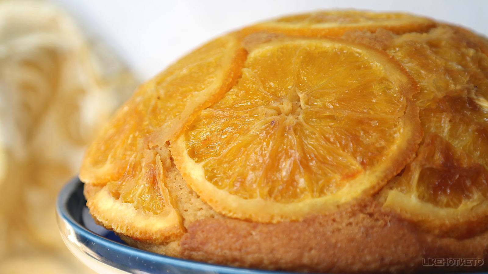 A lovely half hemisphere shaped gluten-free cake covered in golden orange slices.