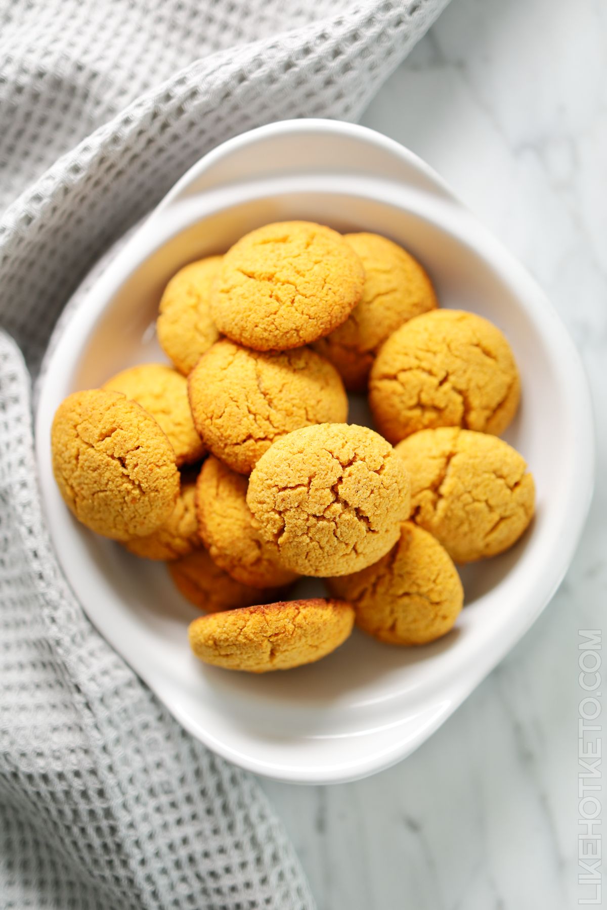 Soft pumpkin keto cookies in a white bowl, viewed from the top.