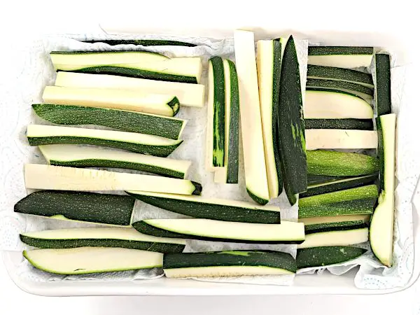 Sliced zucchini resting on paper towels.