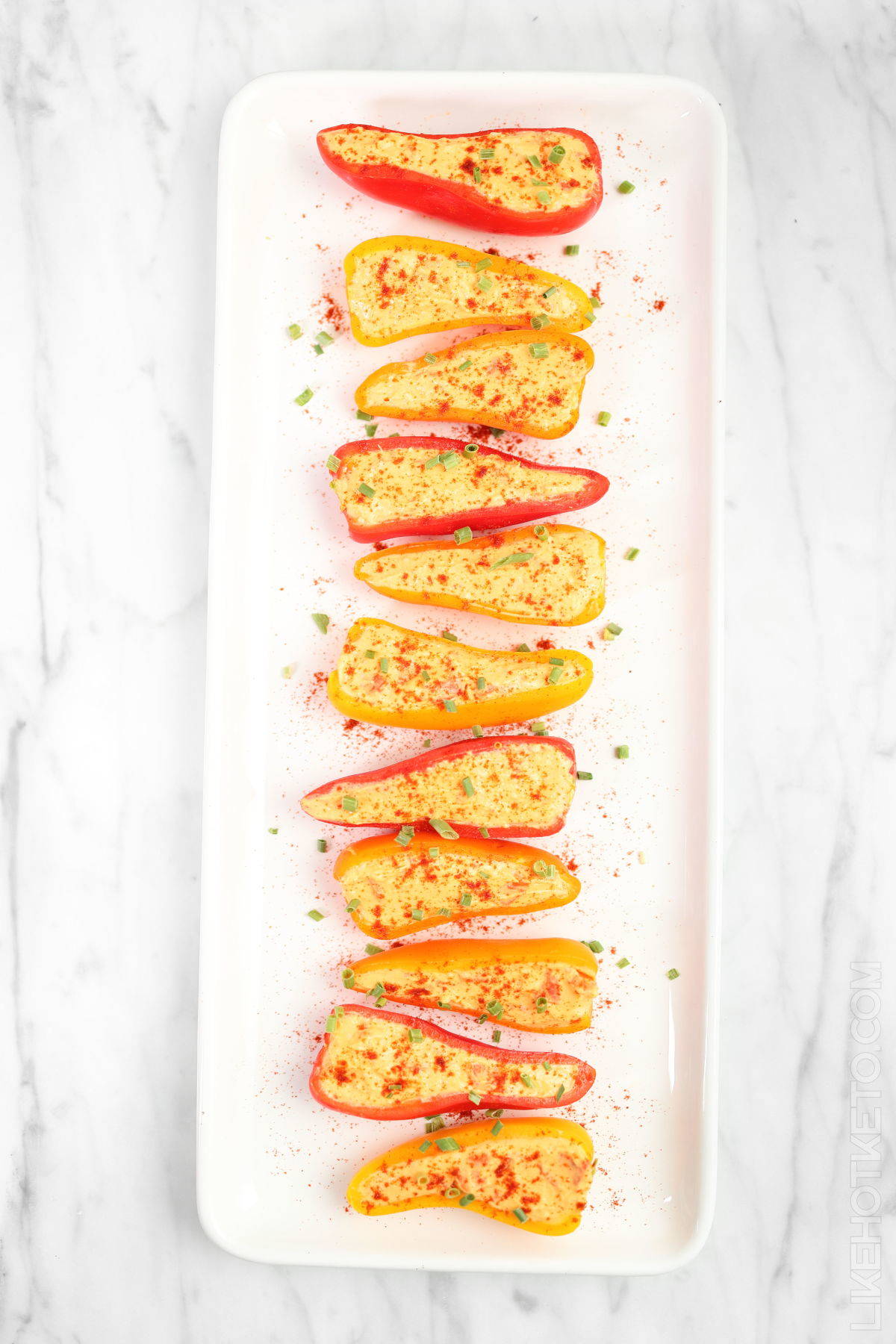 Colorful mini raw peppers stuffed with spicy cheddar Philadelphia cream cheese filling.