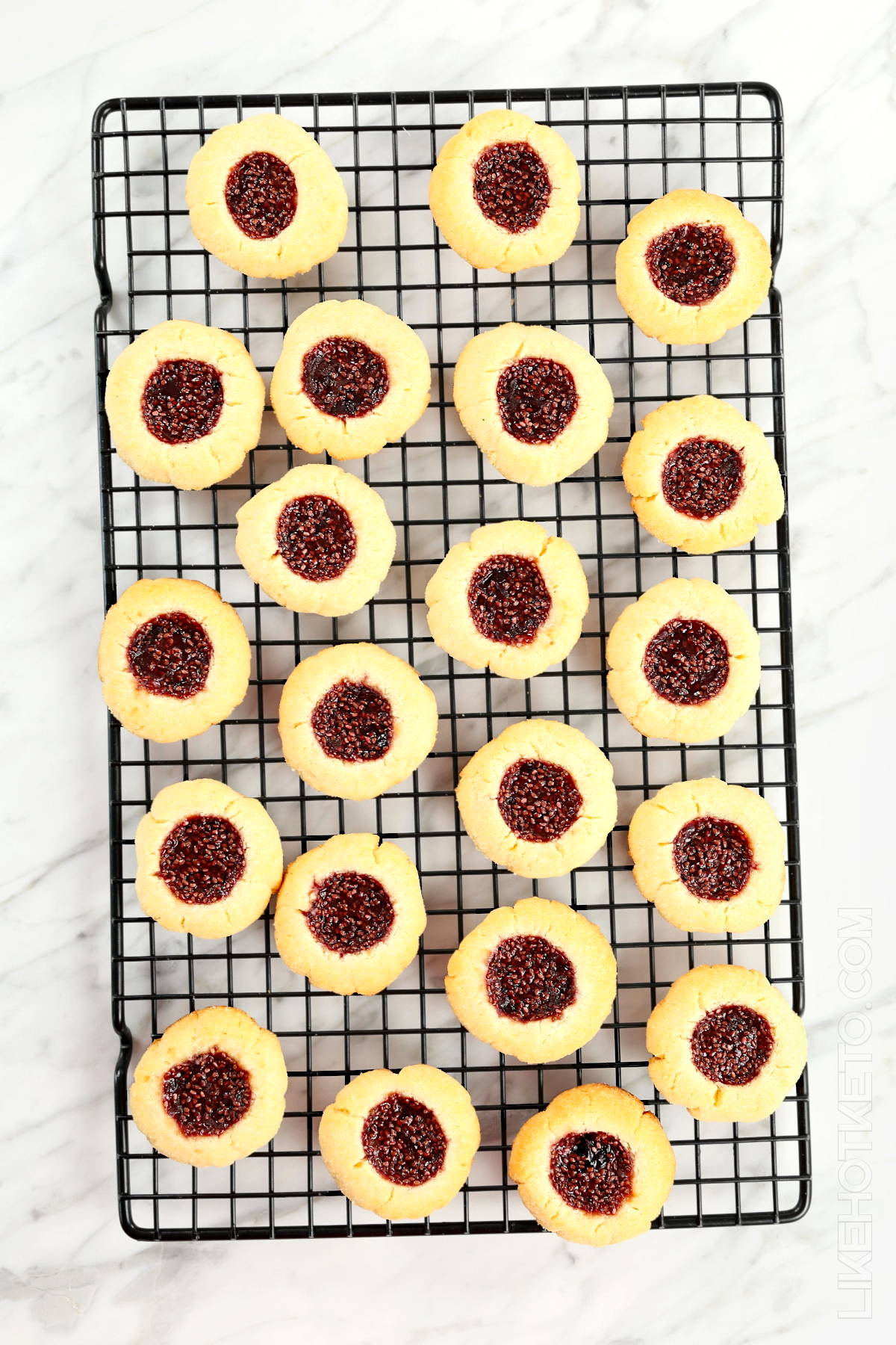 Gluten=free thumbprint jam cookies chilling in cooling rack.