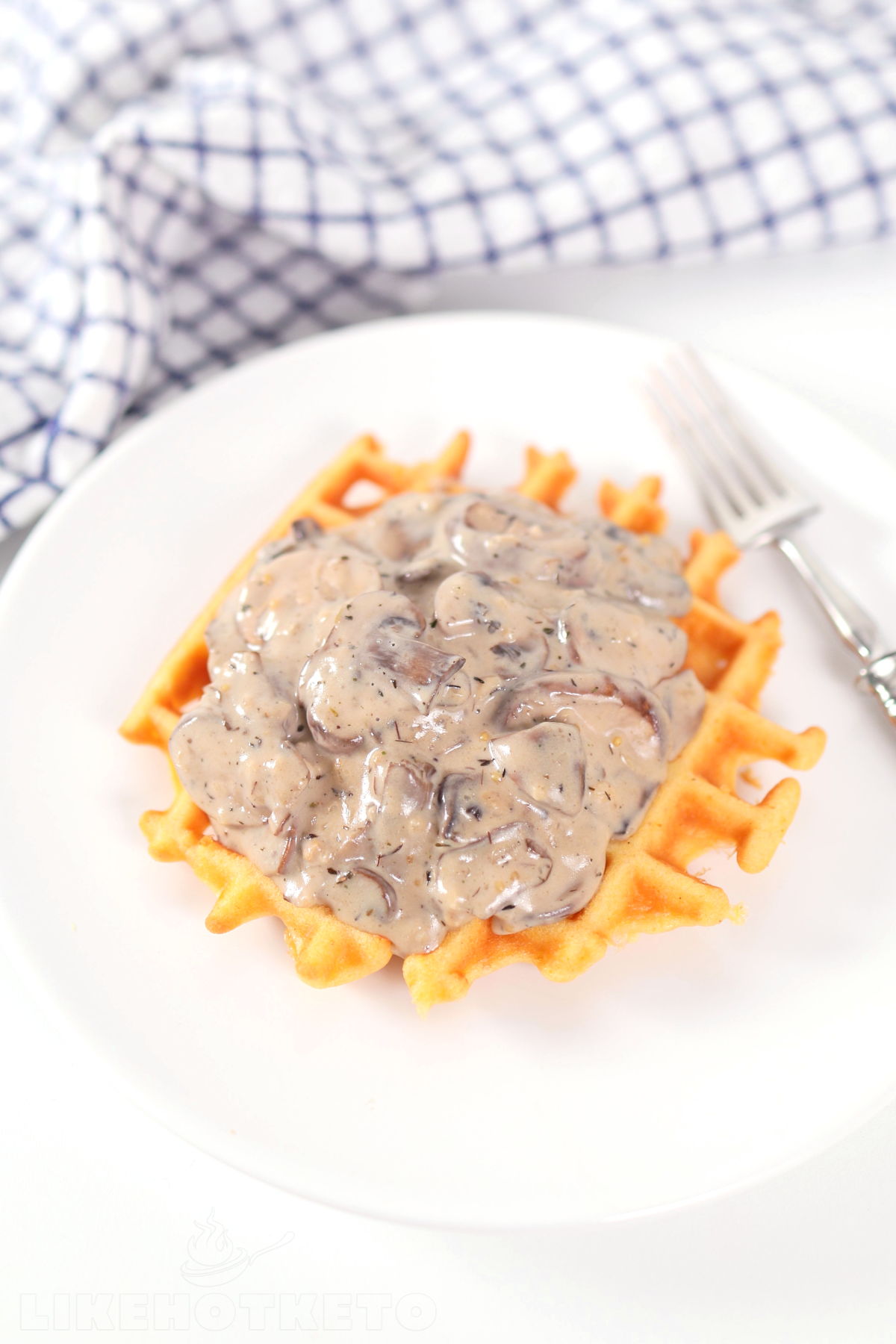 Chicken flour waffle topped with creamy mushroom sauce.