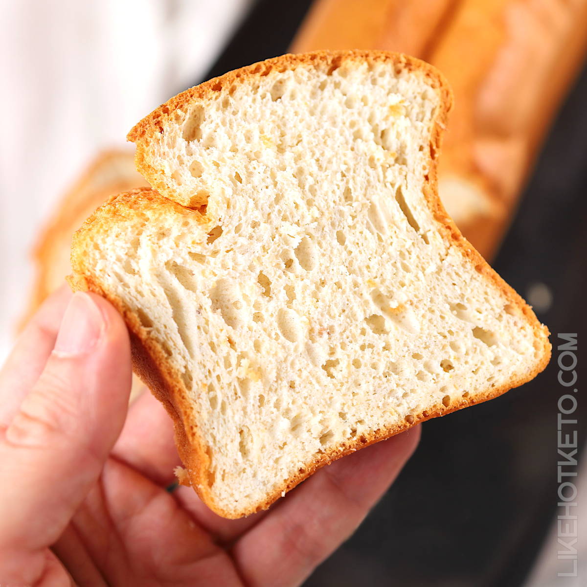 A slice of protein sparing keto bread in hand.