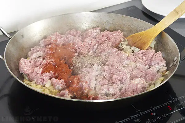 Cooking beef mince with salt and spices.