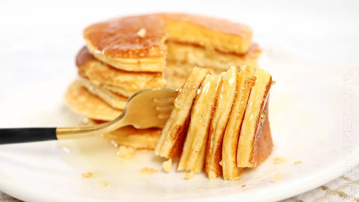 Pieced of whey pancakes with keto syrup on a fork.