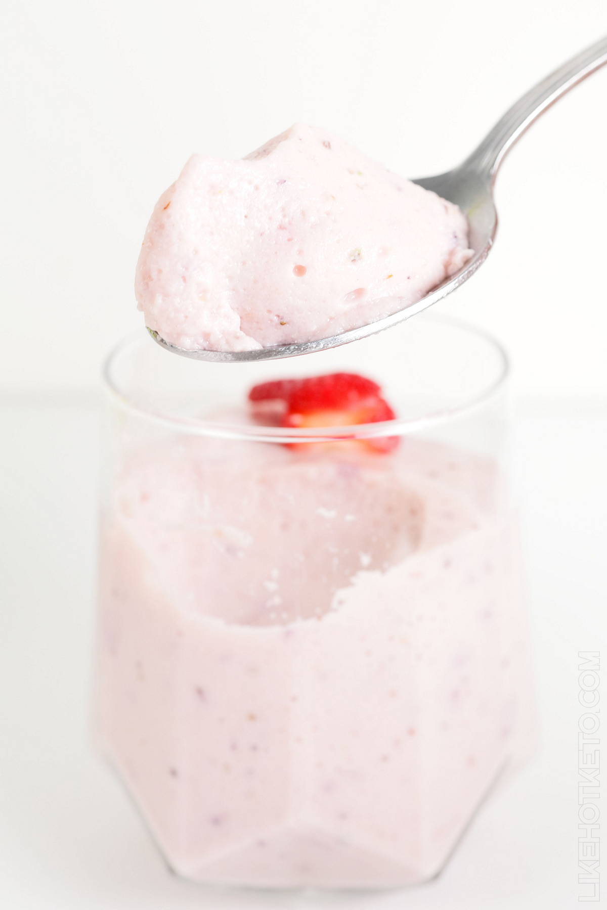 Strawberry yogurt and gelatin fluff on a spoon, with soft mousse texture.