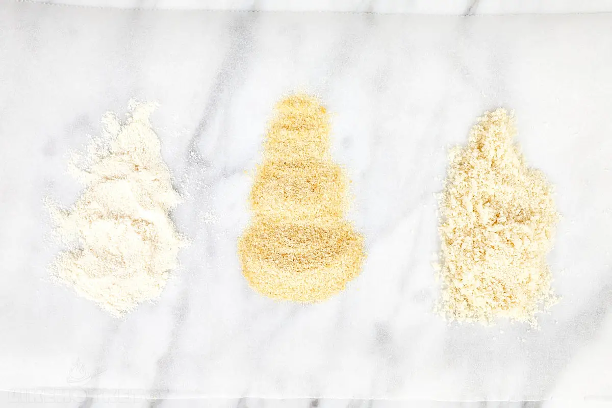 Small amounts of coconut flour, chicken flour and almond flour spread side by side on a parchment paper.