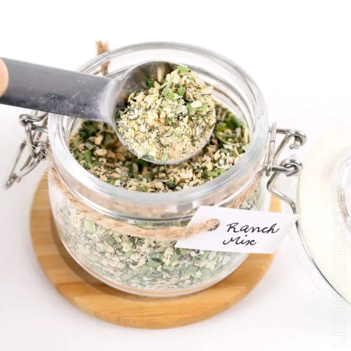 Spoon with ranch seasoning mix over labeled mason jar.
