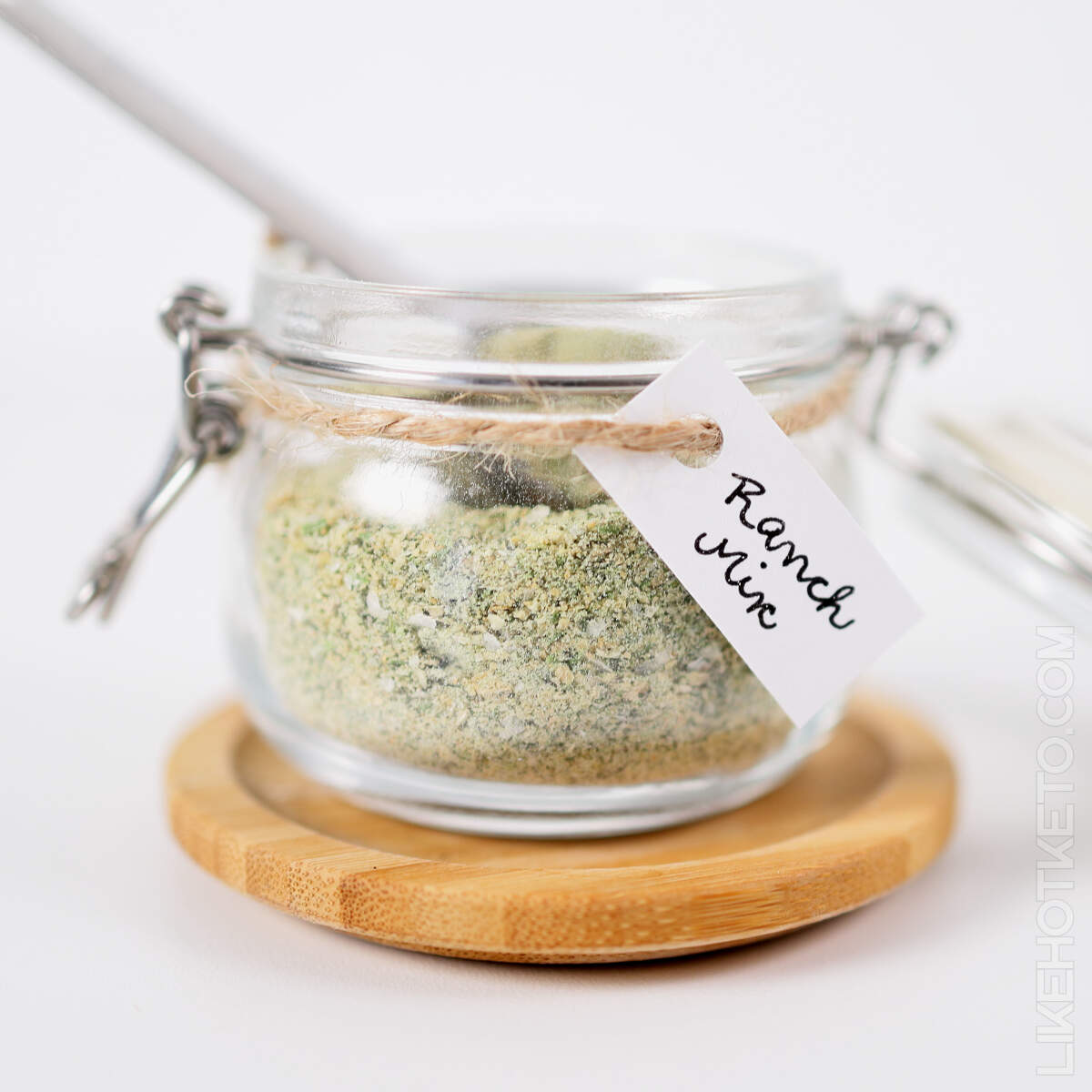 Dry ranch mix powder in mason jar with measuring spoon.