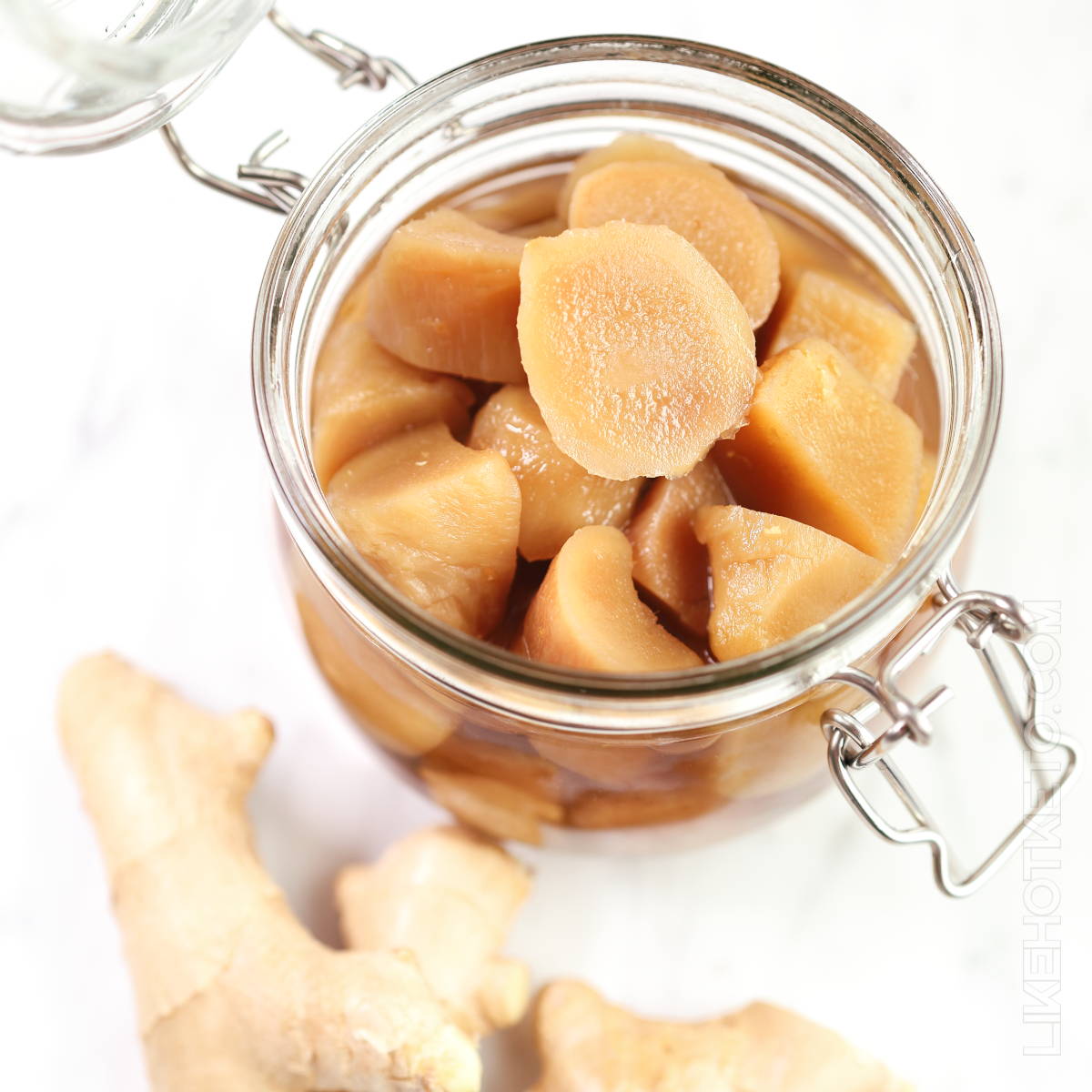 An open mason jar filled with homemade preserved ginger in sugar-free syrup.