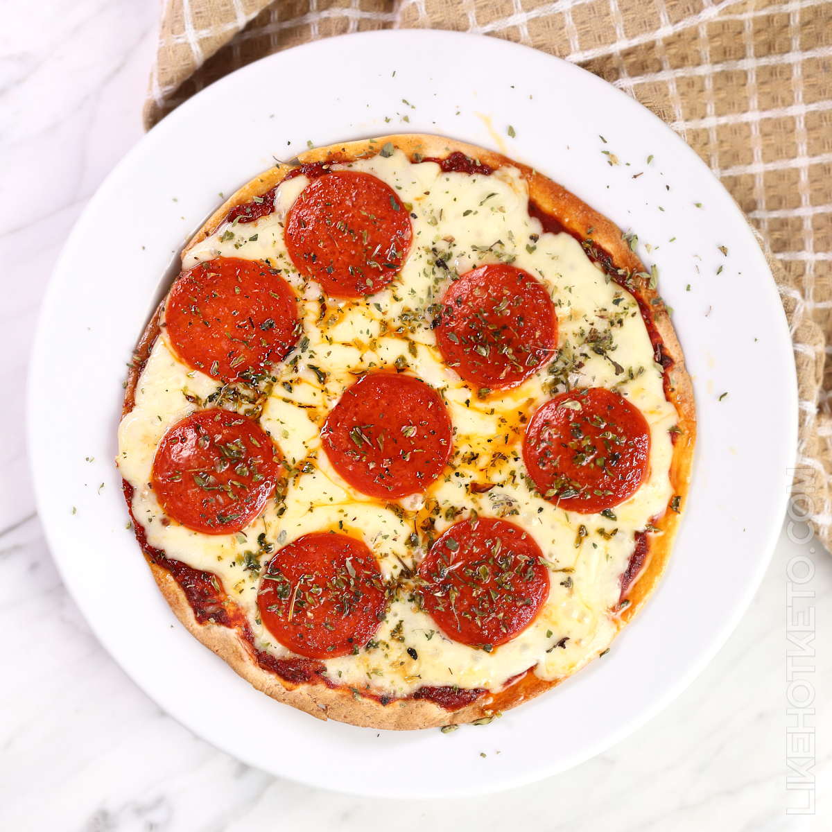Crispy air fryer tortilla pizza in a white serving plate.