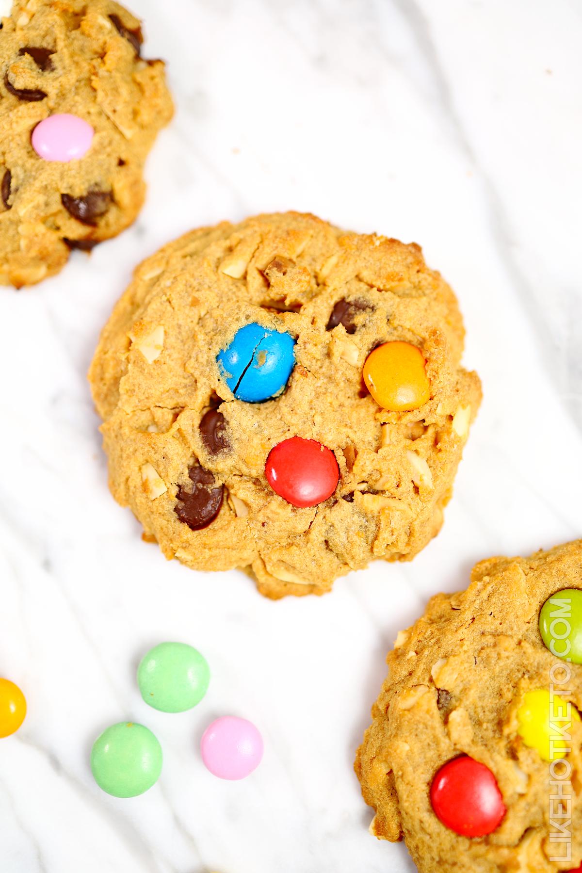 Lupin flour monster cookies on a white marble table with M&M's.