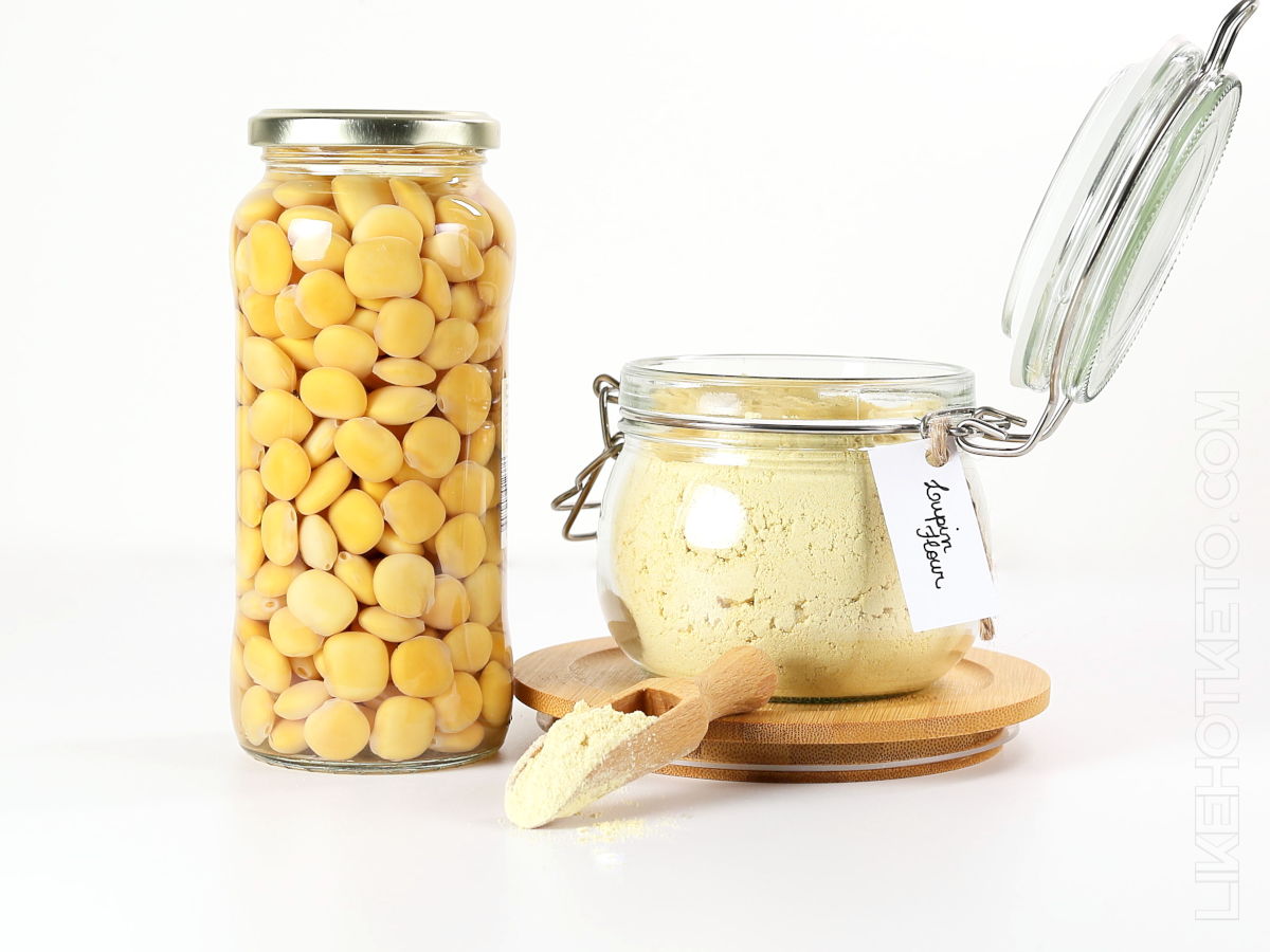 A jar of lupini beans next to a mason jar with lupin flour.