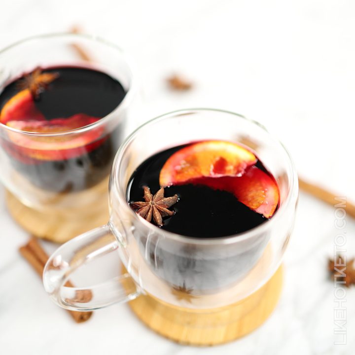 Sugar-free spiced mulled wine in transparent mugs, with orange slices and star anise.