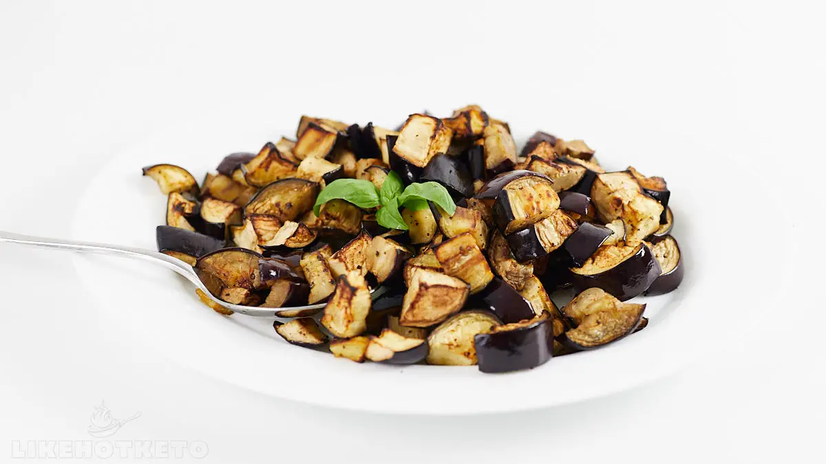 Roasted eggplants on a serving plate with spoon.