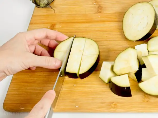 Slicing eggplant in cubes.