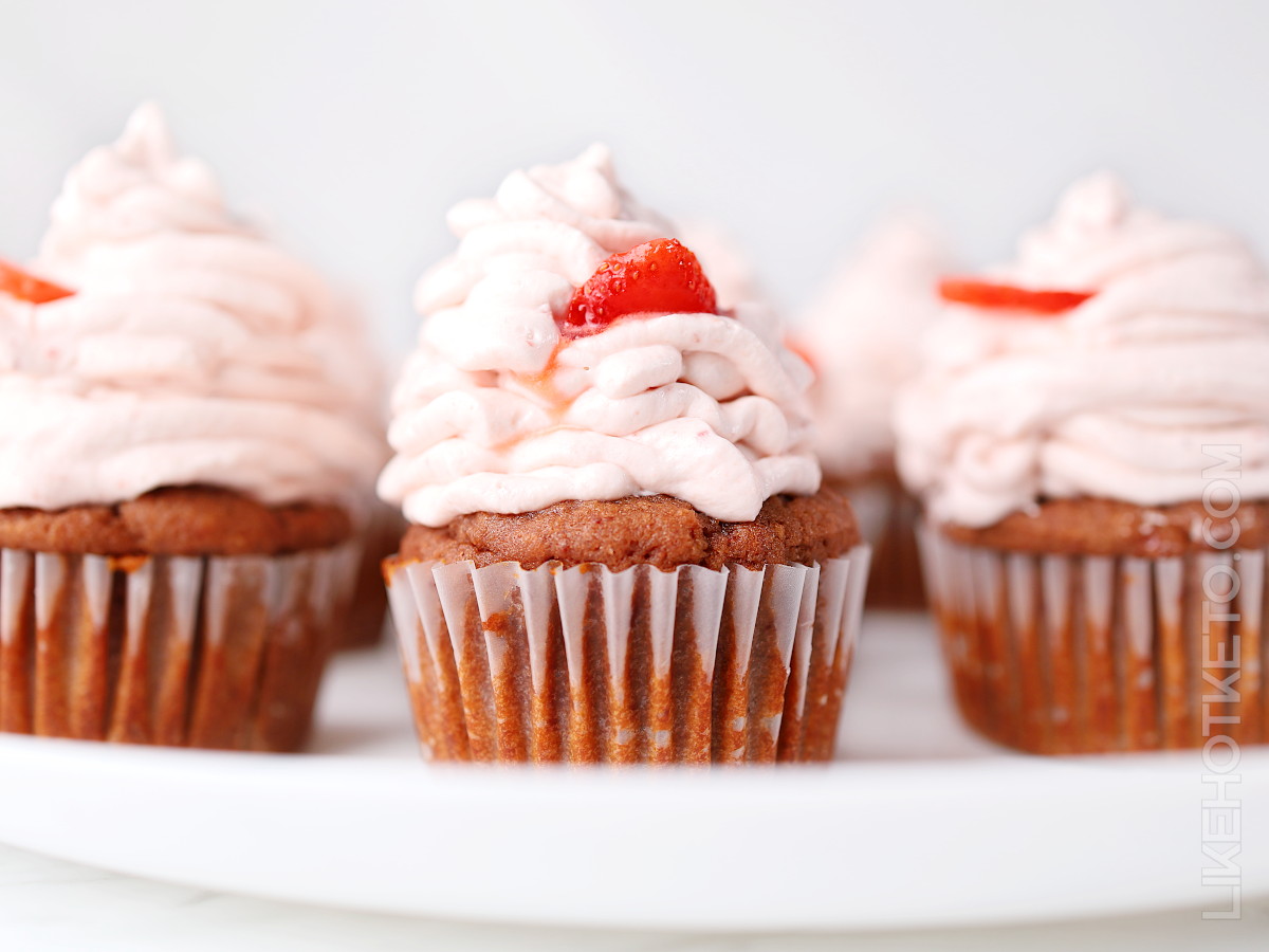 Keto strawberry cupcakes with strawberry cream cheese frosting on a serving plate.