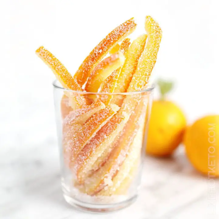 A glass filled with sugar-free candied orange peels rolled in granulated sweetener.