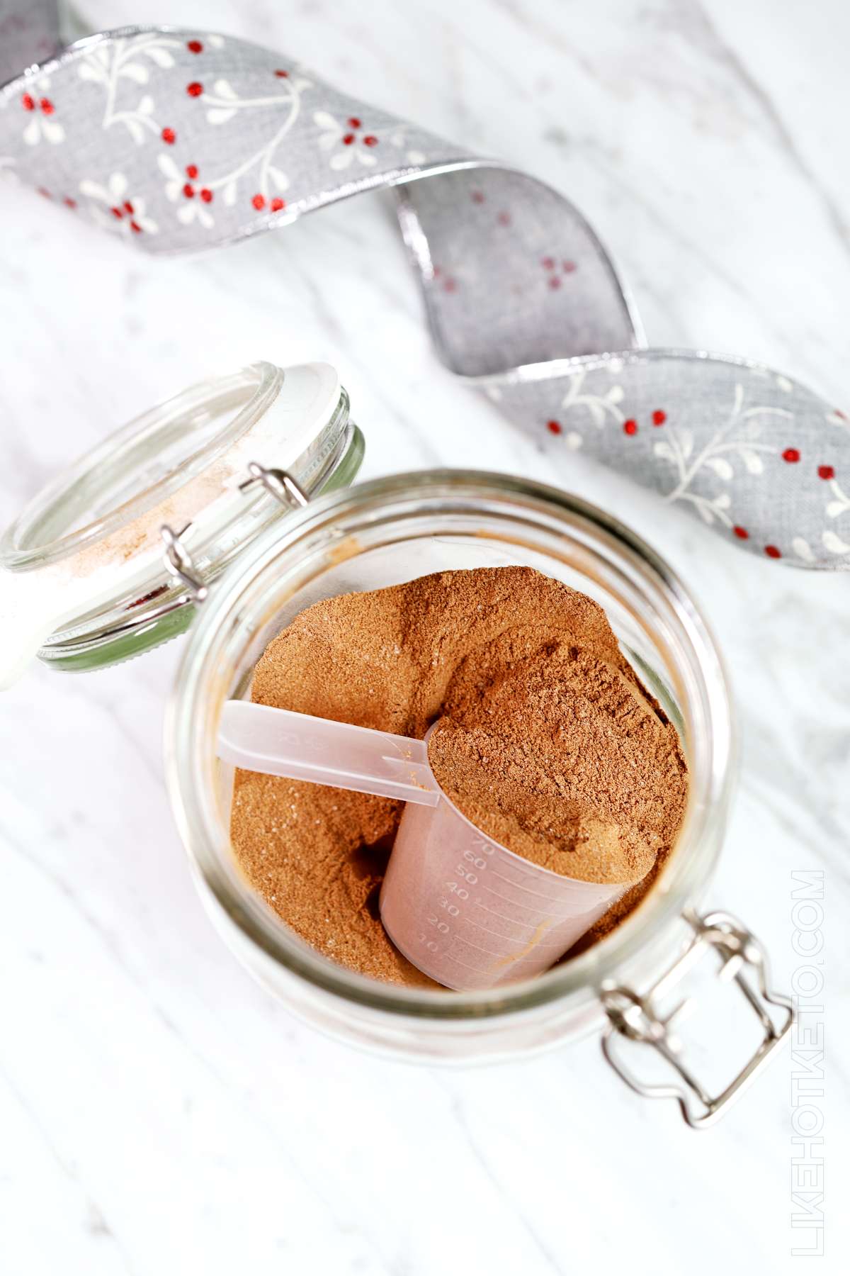 Open mason jar with keto protein hot chocolate mix and whey scoop.