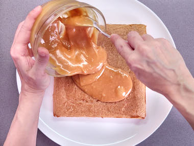 Spreading peanut butter topping.