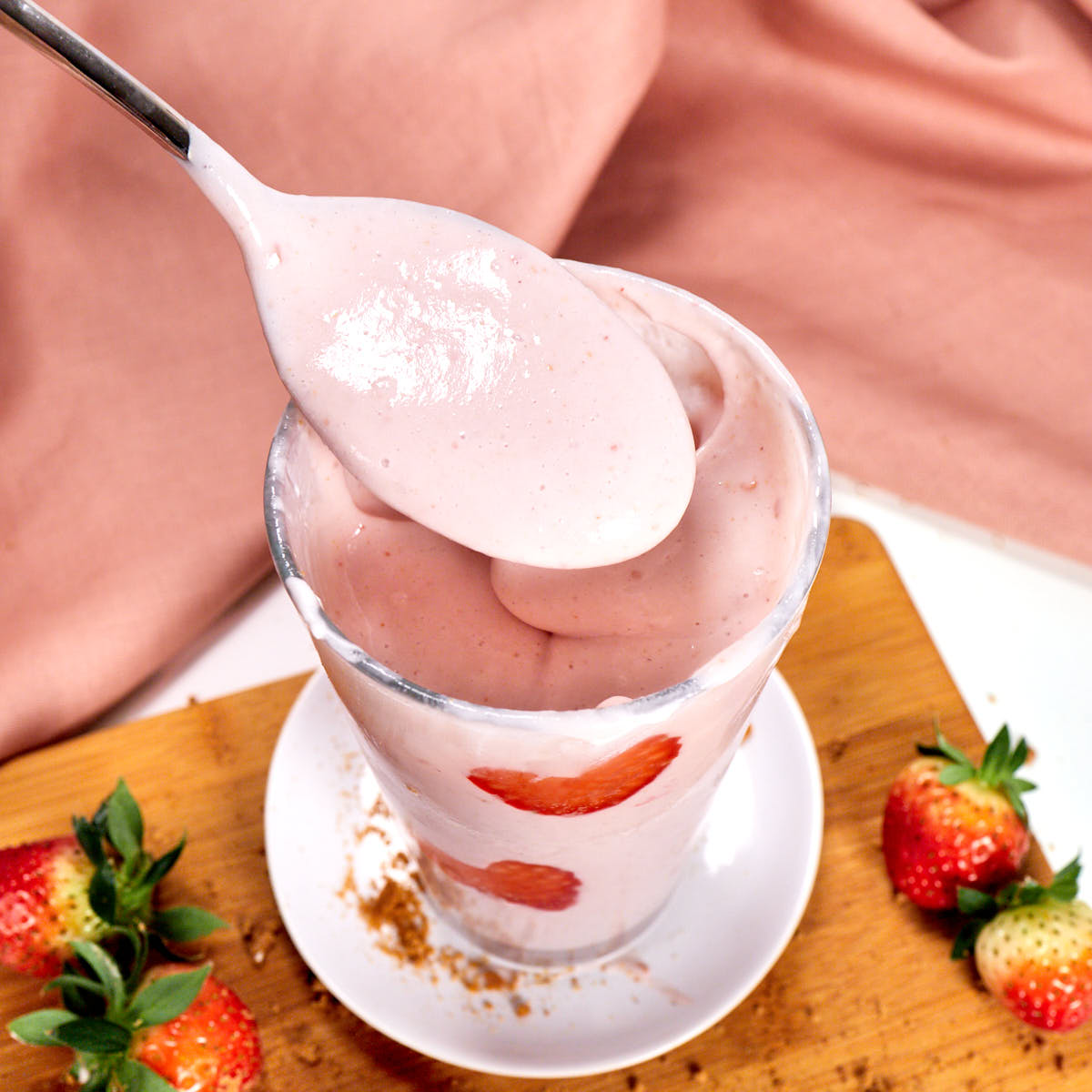 Cream strawberry cheesecake protein shake on a spoon.